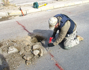 Image 14. Cautiously chiseling detonating cord out of Highway 10 in Fallujah, Iraq. 