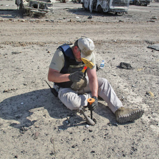 Image 8. Carefully chiseling a mortar out of a parking lot in West Mosul, Iraq.