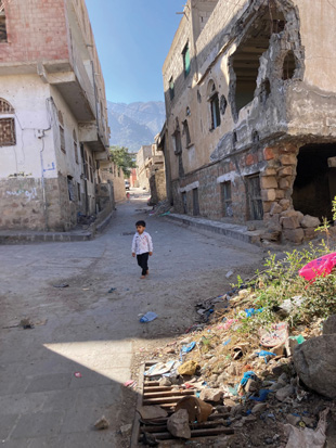 A child plays and roams around a grassy area that is a suspected hazardous area. Image courtesy of The HALO Trust.