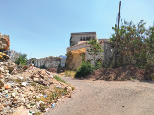 One of Ta’iz’s contaminated streets. An IED has detonated on the left of the image, destroying the side of the house. More contamination is suspected on both sides of the road. Image courtesy of The HALO Trust.