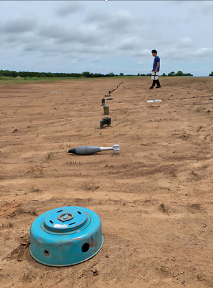 Emplacing EO in a simulated minefield for UAV-based experiments at Oklahoma State University's CENFEX. These EO include anti-tank mines, anti-personnel mines, mortars, and various explosive remnants of war (ERW). Image courtesy of Jasper Baur.