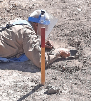 A deminer investigates a suspicious signal. 