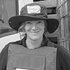 Portrait image of a woman with a wide-billed hat and personal protective equipment.