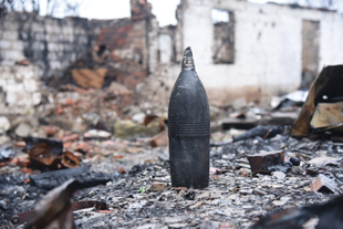 Unexploded ordnance standing upright among debris.