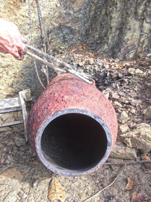 A large, rusted, hollowed-out piece of ordnance.