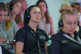 Women wearing headphones and lanyards.