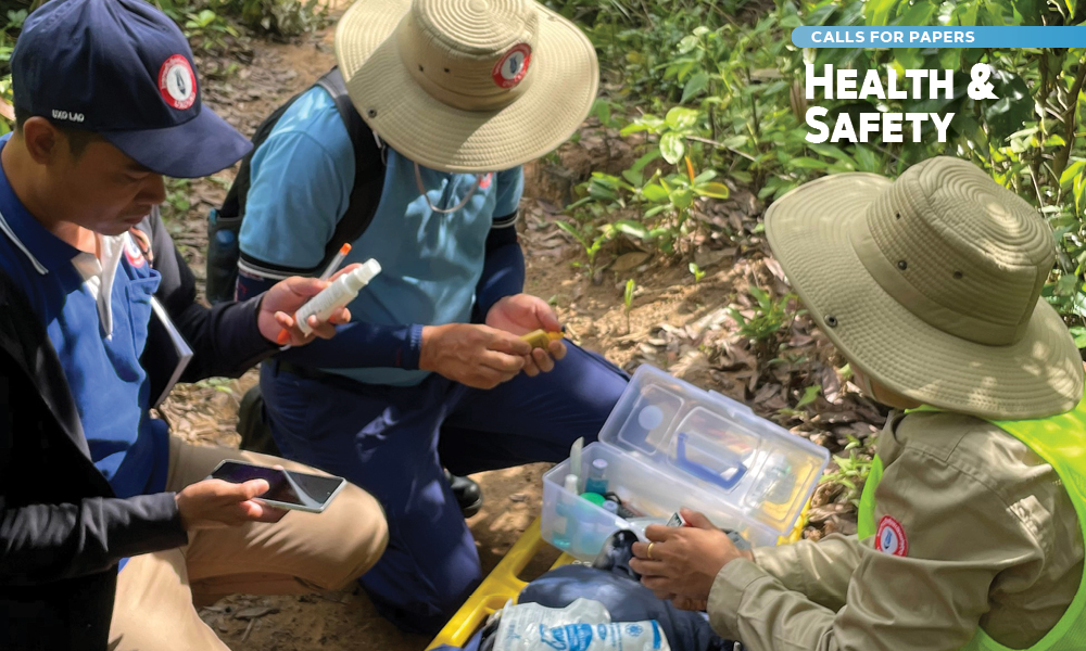 Three deminers examine supplies from a first aid kit.