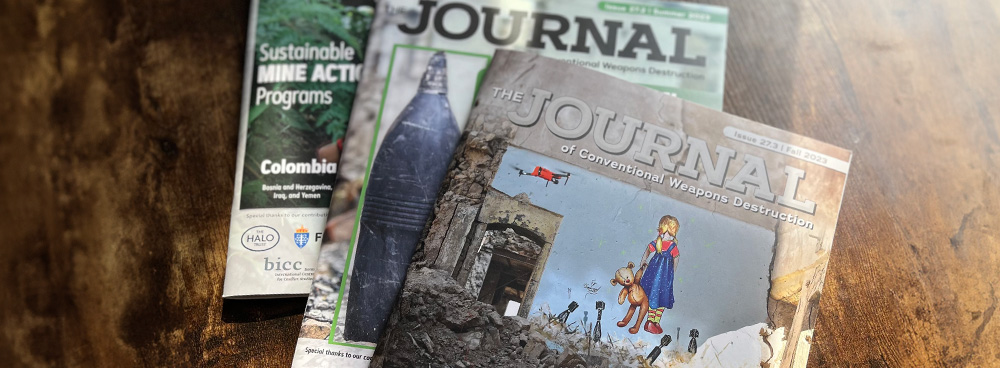 Three magazines spread across a wood desk, the titles read "The Journal of Conventional Weapons Destruction"