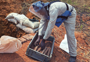 man puts rusty metal objects into a box