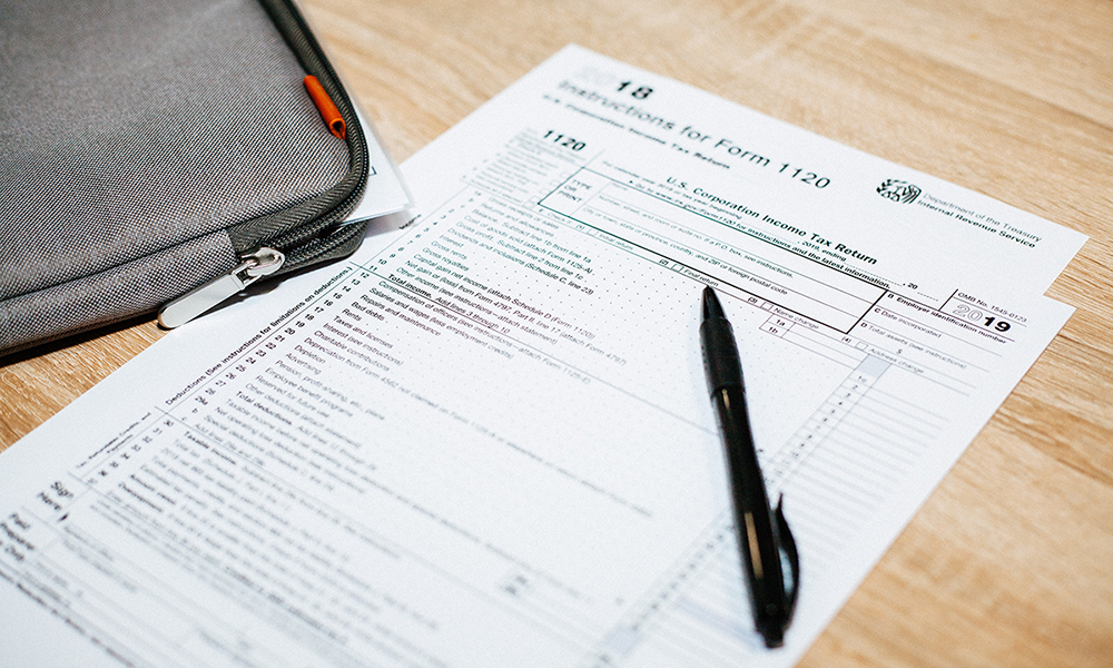 Photo of a tax form with a pen and tablet sleeve