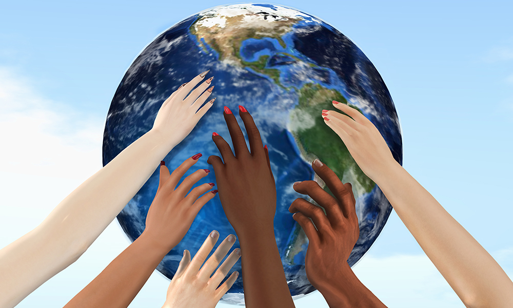Diverse hands reaching toward the globe, together
