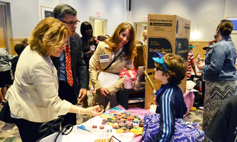 GEM Fair attendees talking to one of the young participants