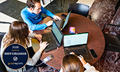 Three students studying with laptops in Showker Lobby (with GradReports Best Colleges badge) - 2020