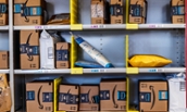 Warehouse shelves full of packages at an Amazon Fulfillment Center (by Jonathan Weiss)
