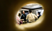 View of attendees of Bagels and Banter through a bagel hole