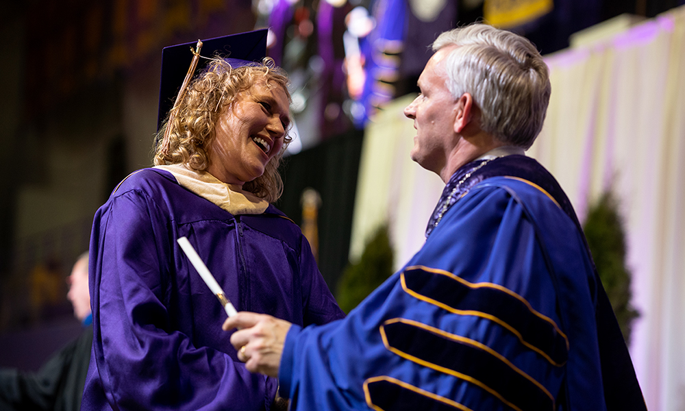 Graduate student receiving diploma from President Alger at 2018 winter commencement