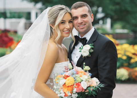 Jordan and Tyler wedding photo, with the bride holding a colorful bouquet.