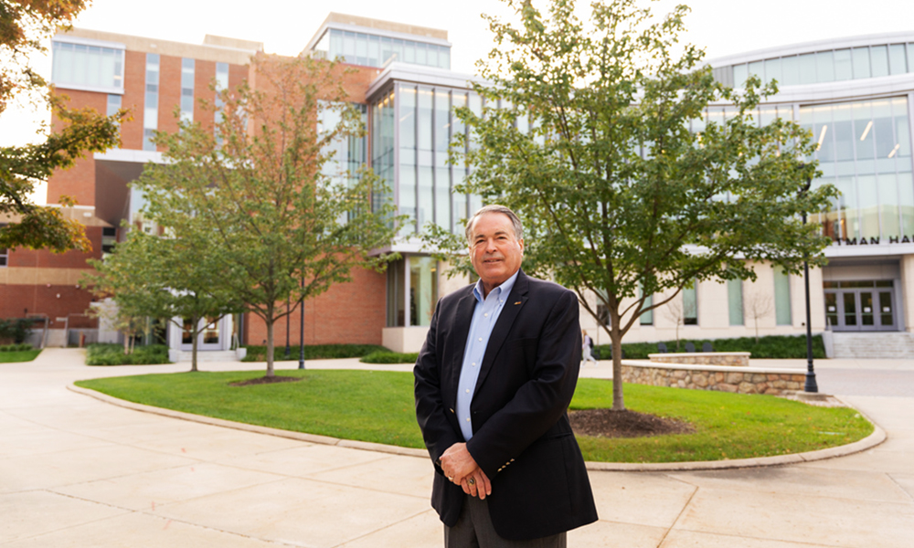 Charlie King poses in front of the new Learning Complex.