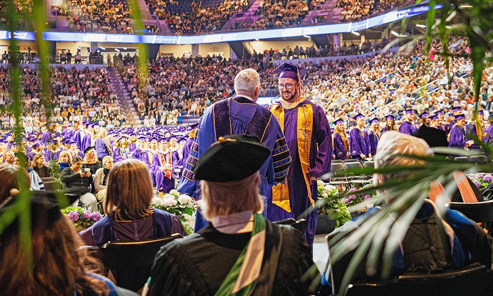 Abstract shot of President Alger shaking hands with a CoB graduate at Commencement