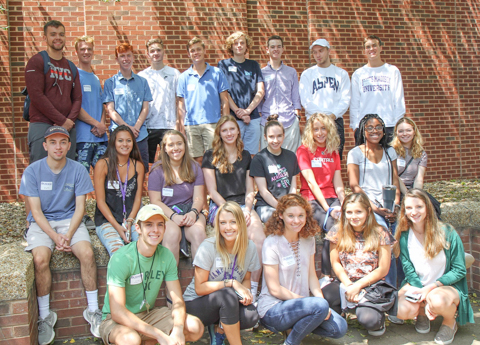 Group of MadizonBiz students posing for a photo outdoors in front of a brick wall.