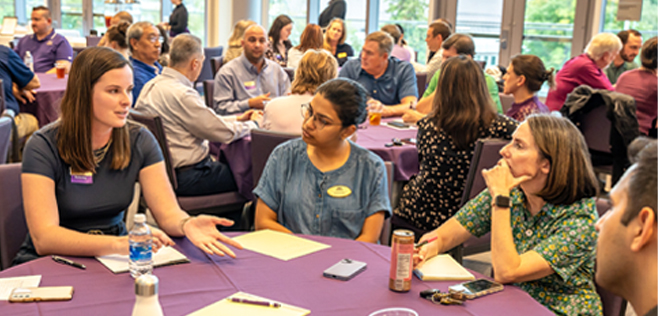 A group of people engaged in conversation at a roundtable during the Young Business Professionals Council event.