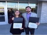 Chris and Ellie posing with certificates they were awarded