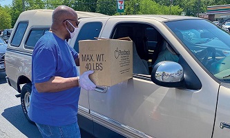 Gilbert giving box of food with mask on