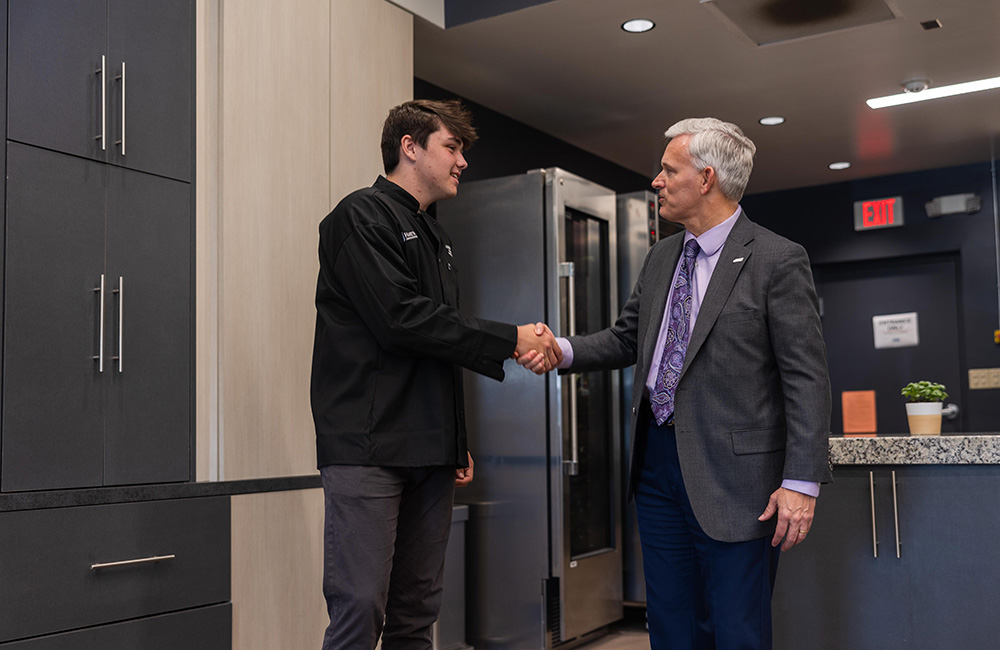 President Alger shaking hands with Bobby's son