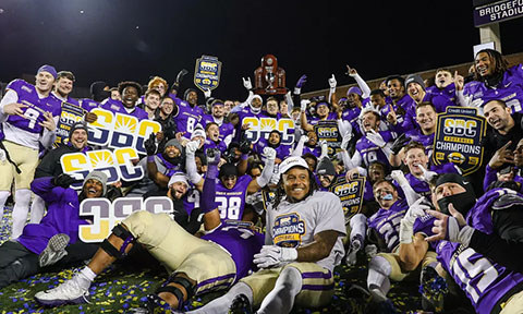 JMU football players celebrating the conference win.
