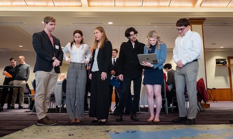 Students standing over a large map and analyzing it.