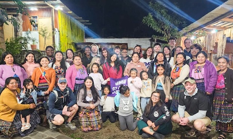 A group of JMU Study Abroad students posing with host families in Guatemala