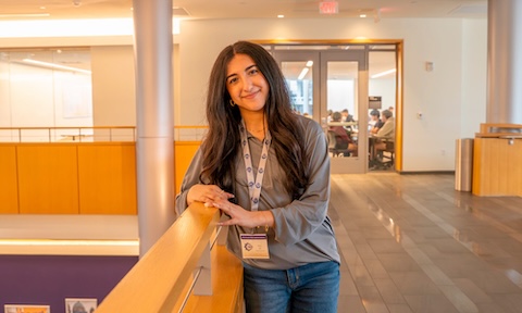 Sana Jaf standing outside of a classroom smiling at the camera