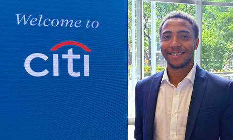 Jordan Lucas stands next to the Citi sign at his internship.