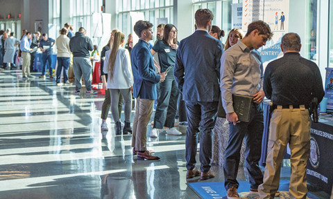 Many students in business attire attending a career fair.