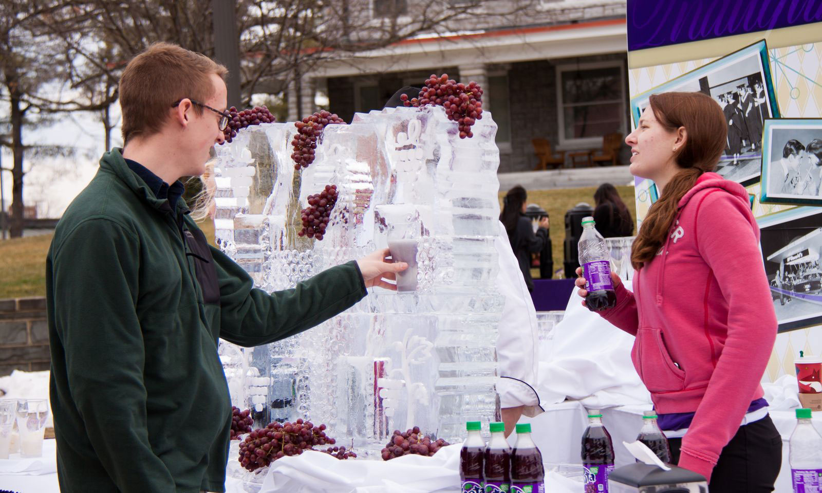 Student filling his commemorative inauguration glass at the ice luge with a grape ice cream fizz.