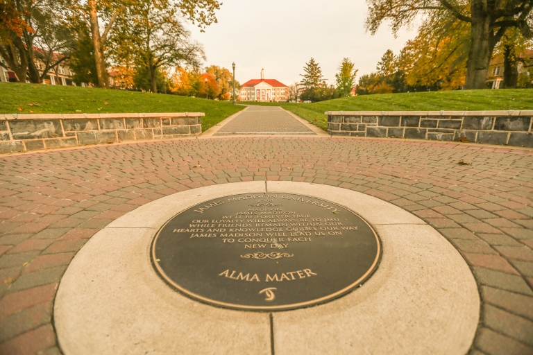 A view of the Alma Mater seal on the Quad with Wilson Hall in the distance.