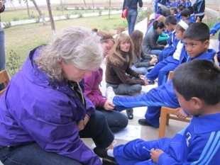 Maggie Evans fitting shoes on child in Peru on a TOMS Coprodeli Giving Trip