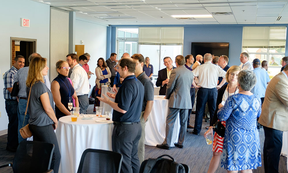 Crowd mingling in a large room.