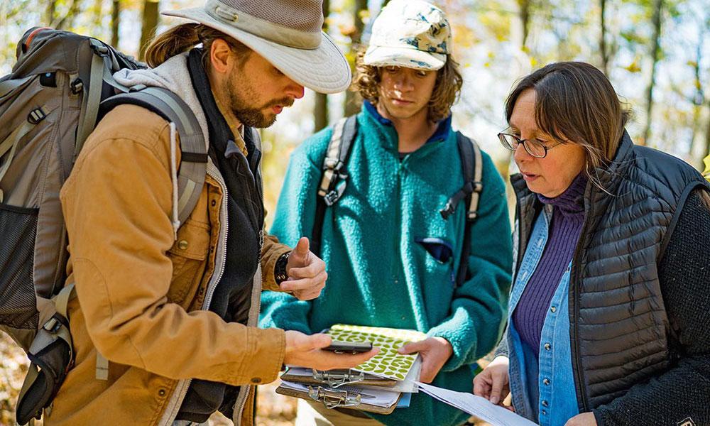 Carole Nash with two male students in Shenandoah National Park cemetery