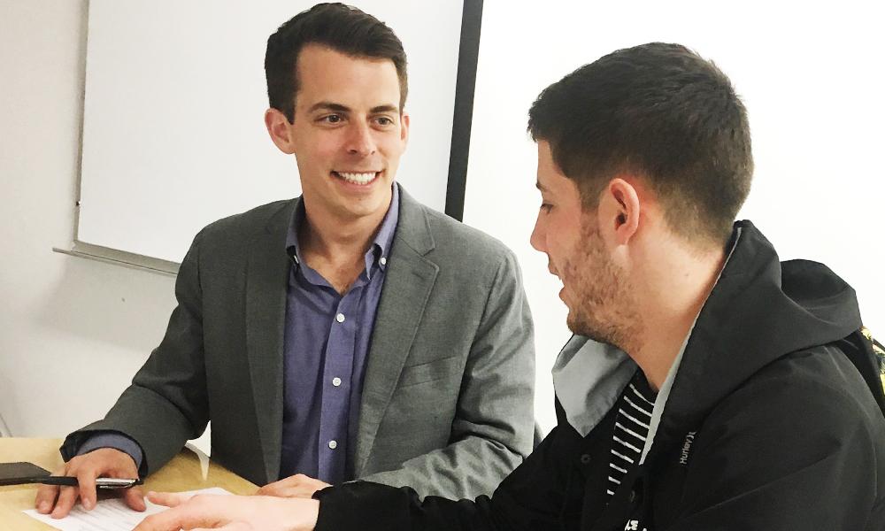 JMU Alum, Jesse Wright (left), spends time reviewing resumes with a student in the Business of New Media class.