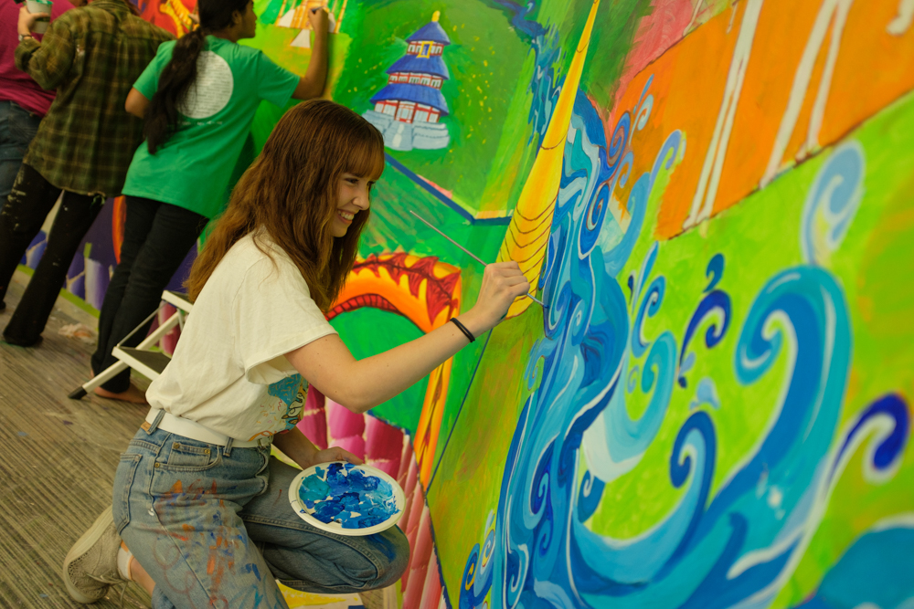 students painting wall in Center for Global Engagement