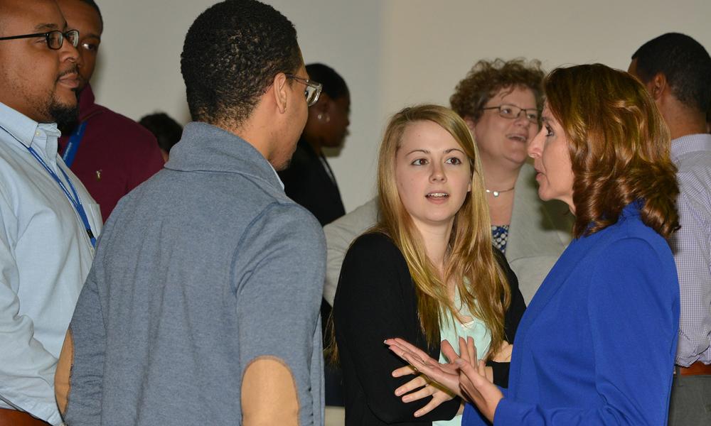 Photo of Kathy Warden talking to early-career employees at a town hall meeting