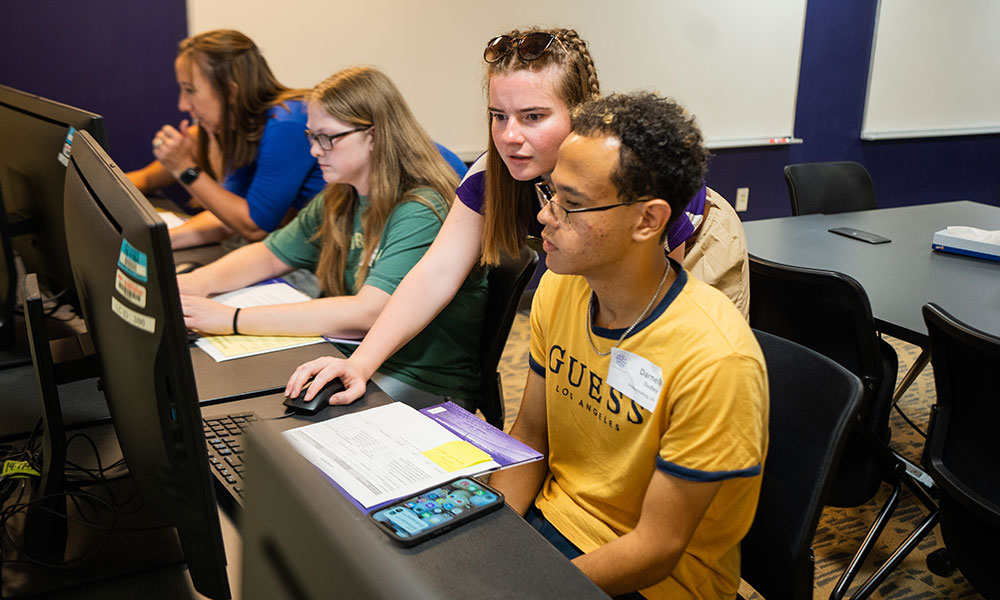 Springboard academic adviser helps a student at a computer