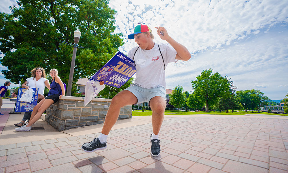 Happy student dances with his yard sign