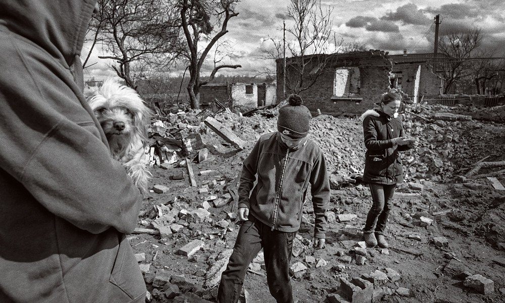 black and white photo of survivors of the war in Ukraine surrounded by destruction captured by Sean Sutton/MAG