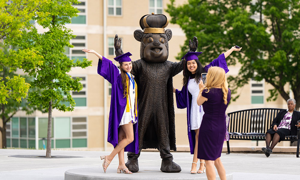 Duke Dog statue with graduates having their picture taken