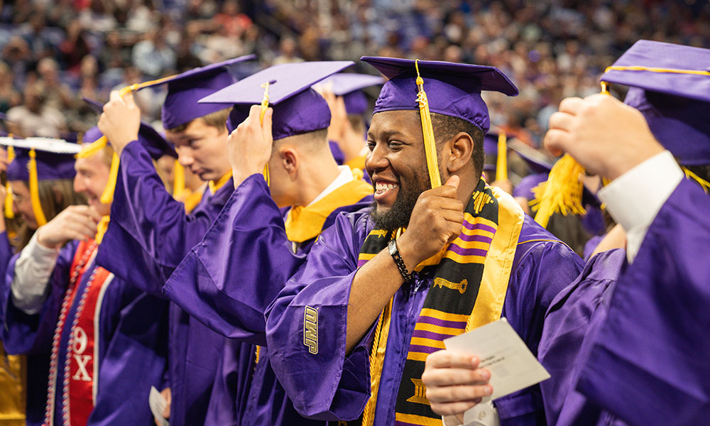 graduates moving their cap tassels over to the other side