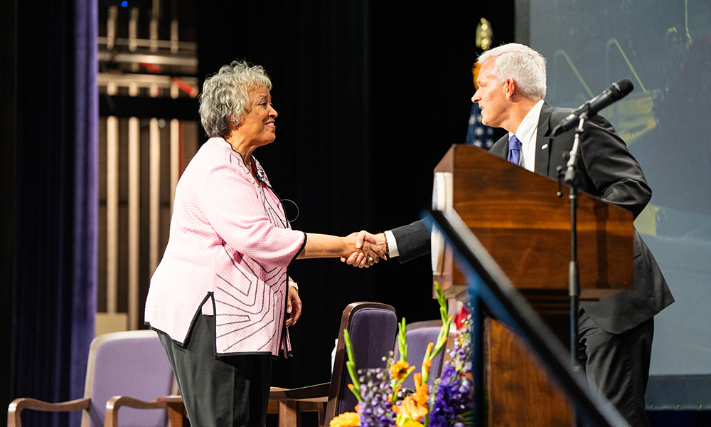 Kay Coles James and JMU President Jonathan R. Alger shake hands on the stage of Wilson Hall