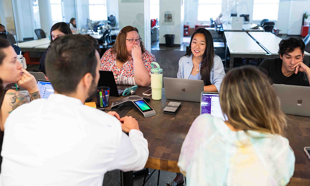 JMU alumni in a staff meeting in a conference room at The Martin Agency