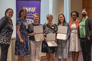 The UPCARE team poses for a photo while holding their awards.